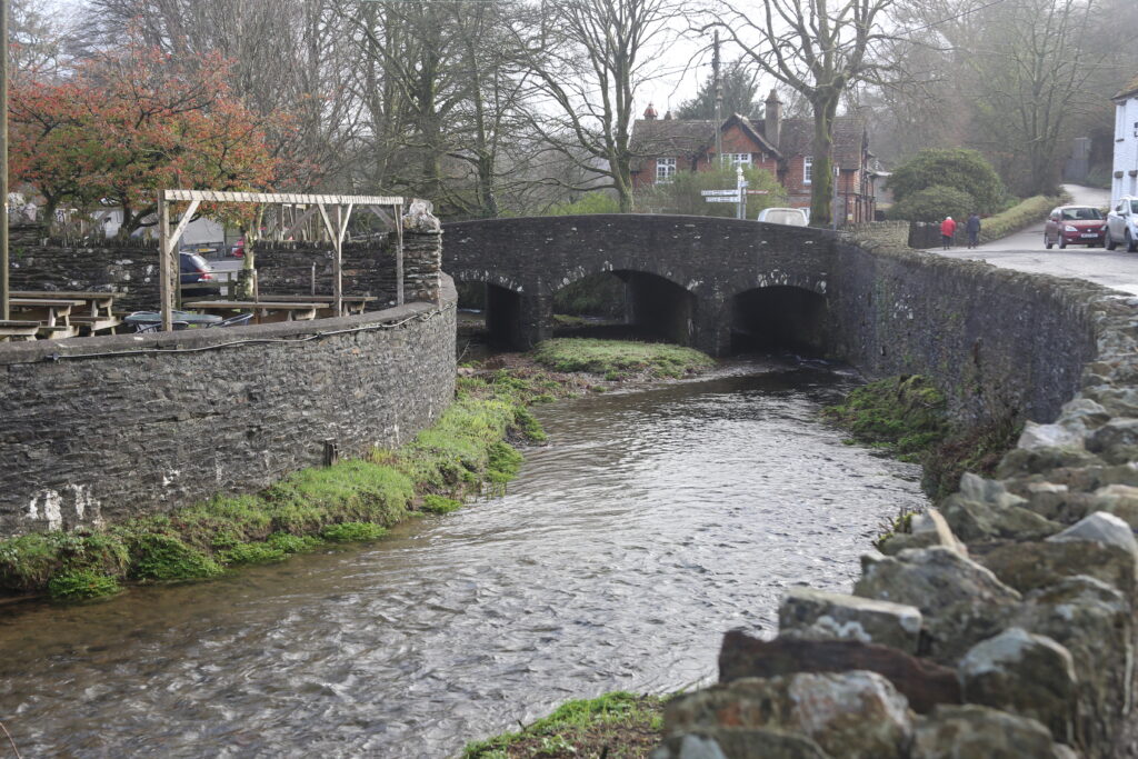 River bending under three arch bridge