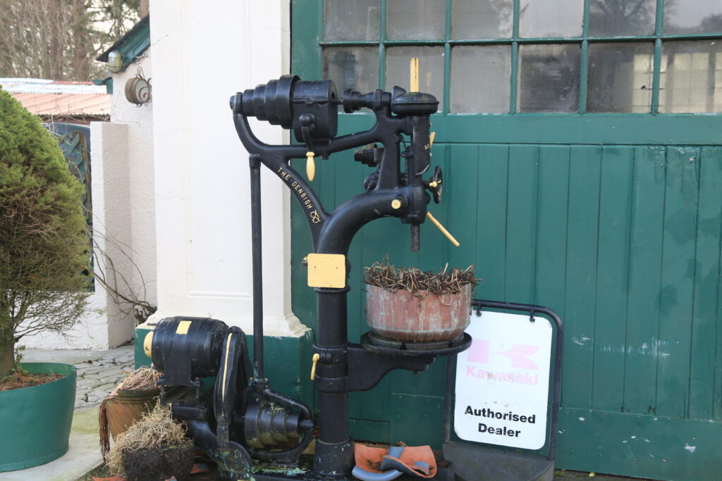 Old drilling machine being used a flower pot stand
