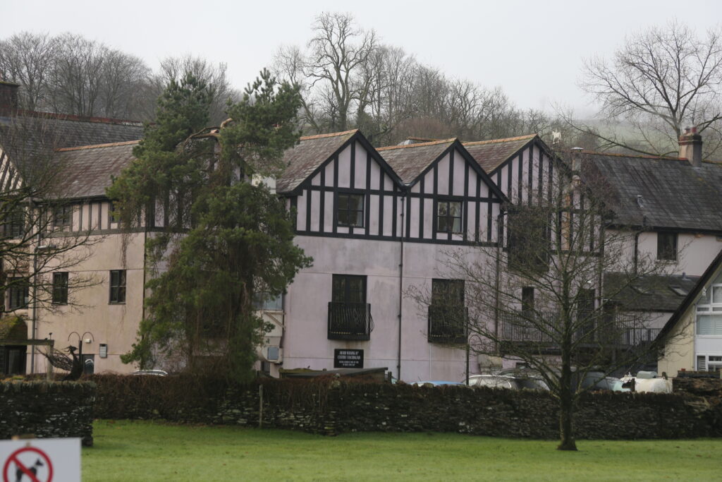 Pink building with Dark wood frame and a slate tiled roof
