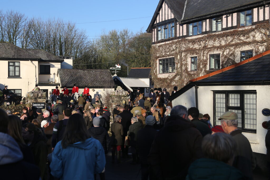 Hunt Riders in Red coats, one giving a speech to the assembled crowd