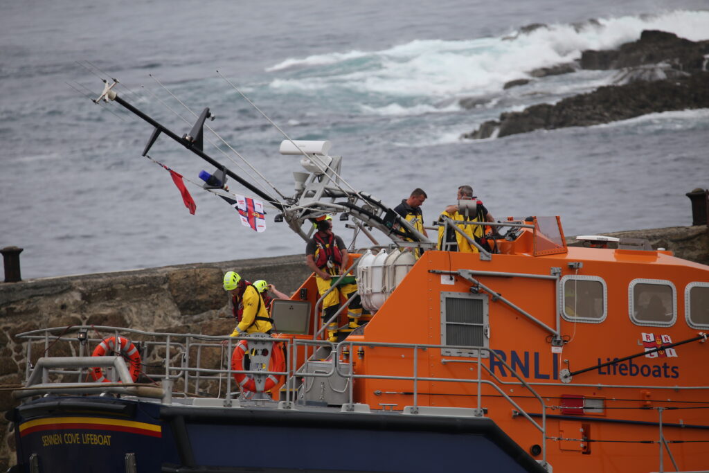 Lifeboat mast being lowered so that it can fit into the boathouse 