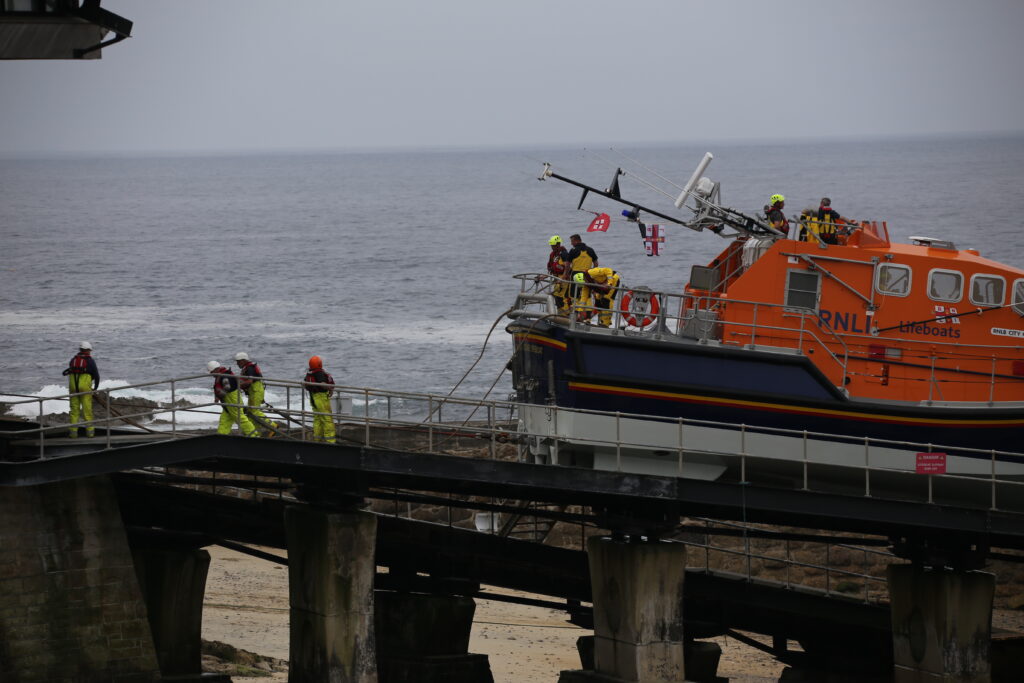 Crew preparing ropes to tow lifeboat back up the ramp