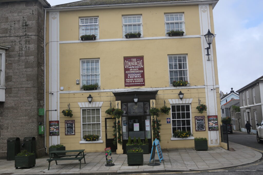Hotel Front and entrance of The Commercial, a creamy yellow façade .