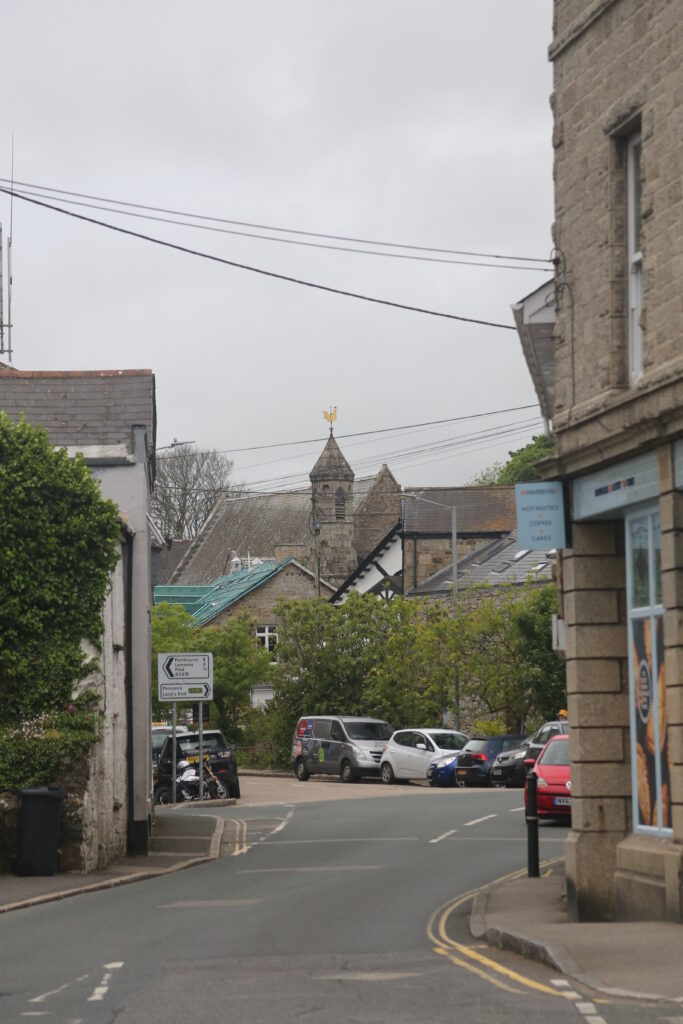 view of the street, there is a gold coloured weather vane in the distance