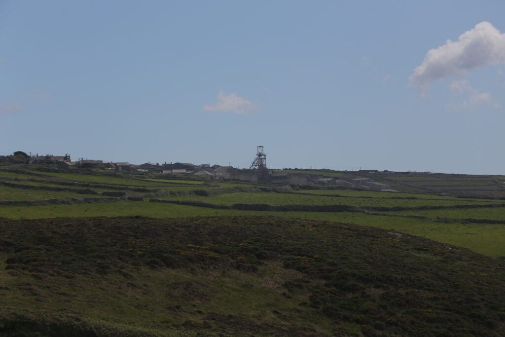 Green fields, with a mining winch in the background